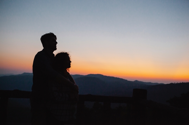 Paar schaut auf Landschaft bei Sonnenuntergang