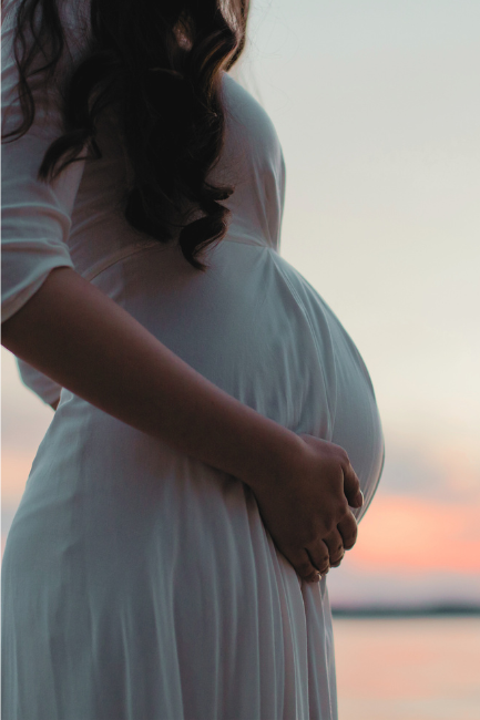 Schwangere Frau im Sonnenuntergang voller Vertrauen und Vorfreude auf die Geburt dank dem Hypnobirthing Onlinekurs