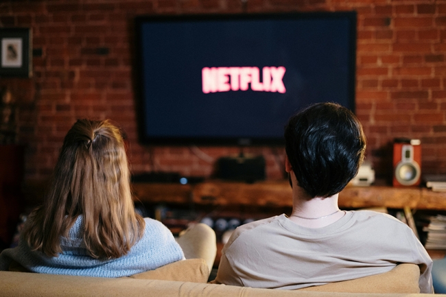 Pärchen sitzt vor dem Fernseher und schaut Netflix statt das Nervensystem zu regulieren