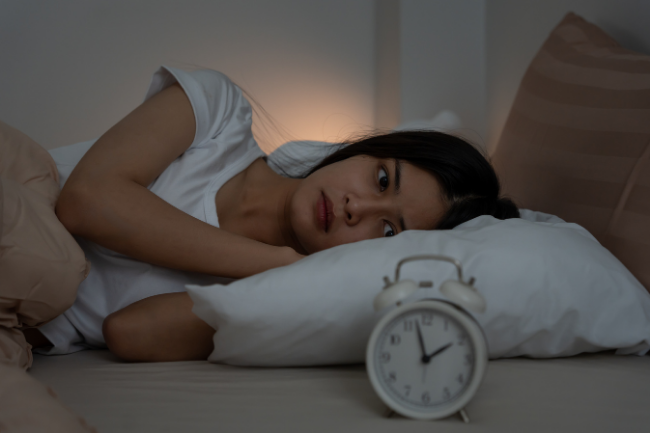 Frau liegt wach im Bett ihr Nervensystem kann nicht regulieren