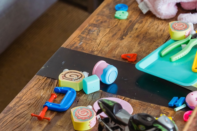 Chaotischer Couchtisch mit Spielzeug: Der visuelle Trigger für Mama-Stress und Reizüberflutung